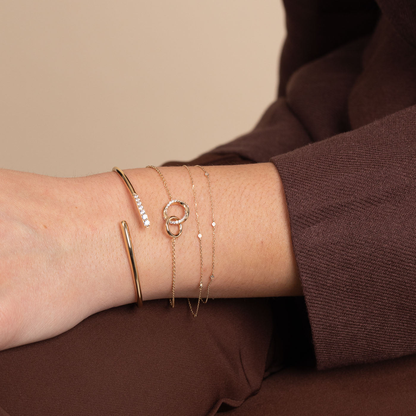 Topaz Charm Bracelet in Solid Gold worn layered with other bracelets