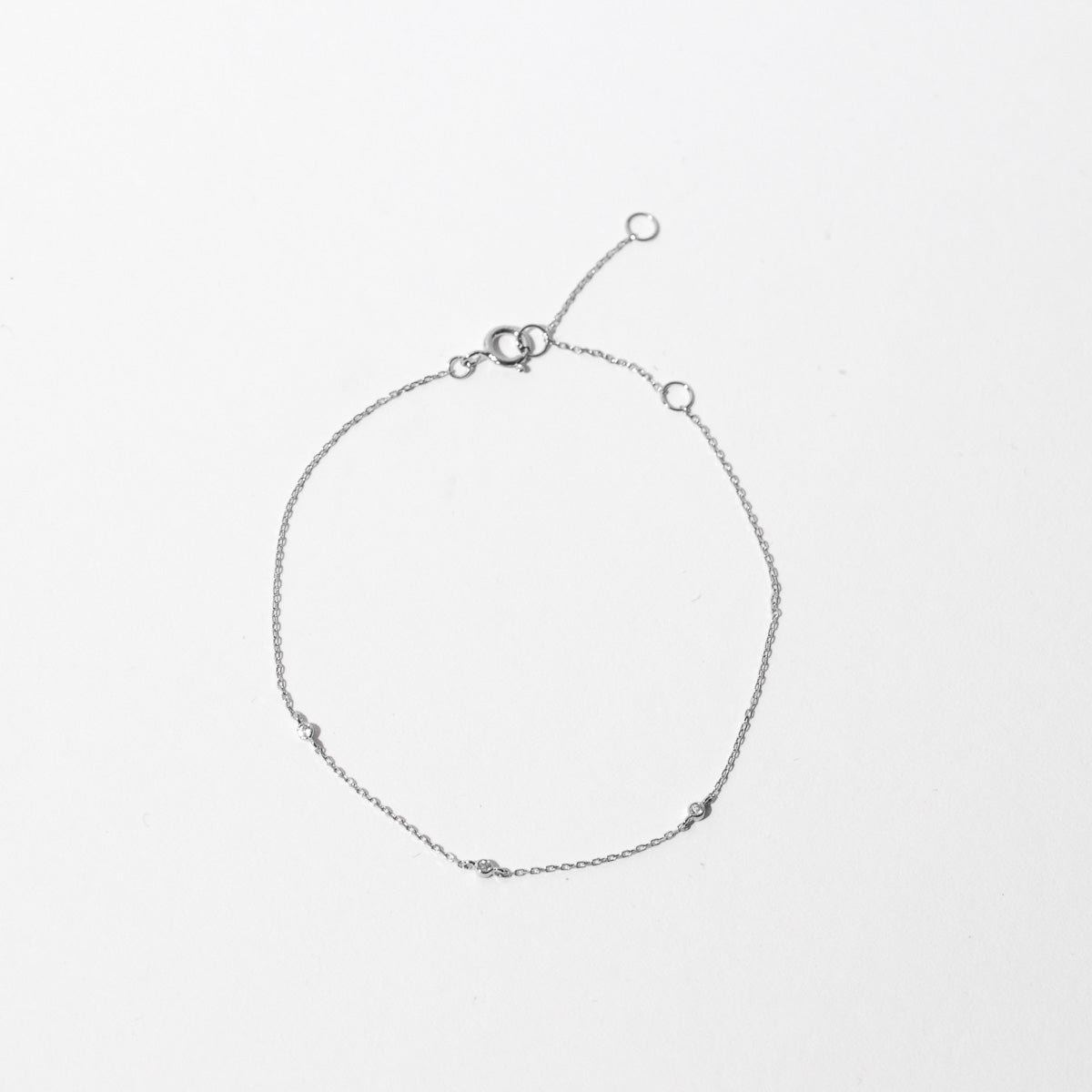 Topaz Charm Bracelet in Solid White Gold flat lay