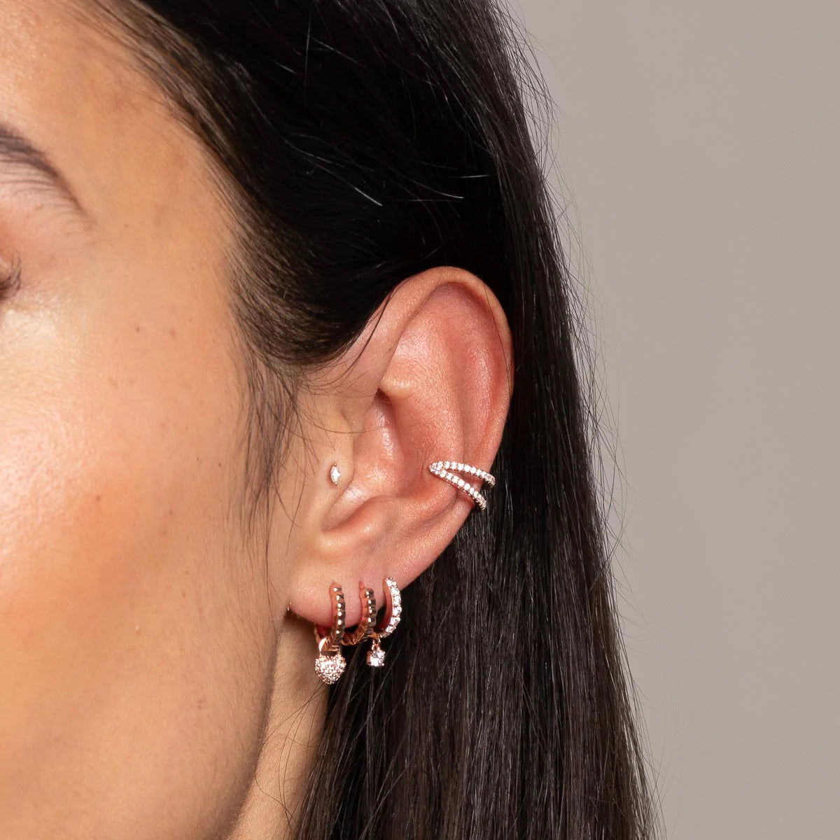 Charm Crystal Huggies in Rose Gold worn with other earrings