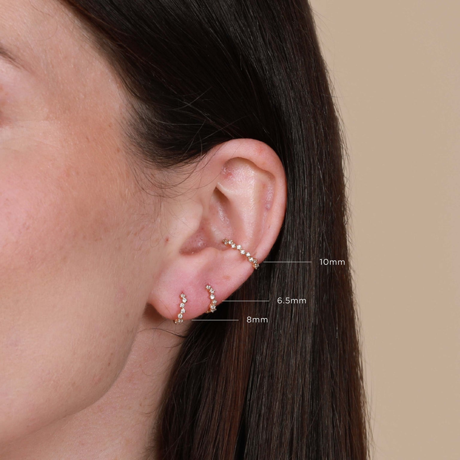 Worn shot of Cluster Hoop 8mm in Gold in front lobe with other sizes labelled