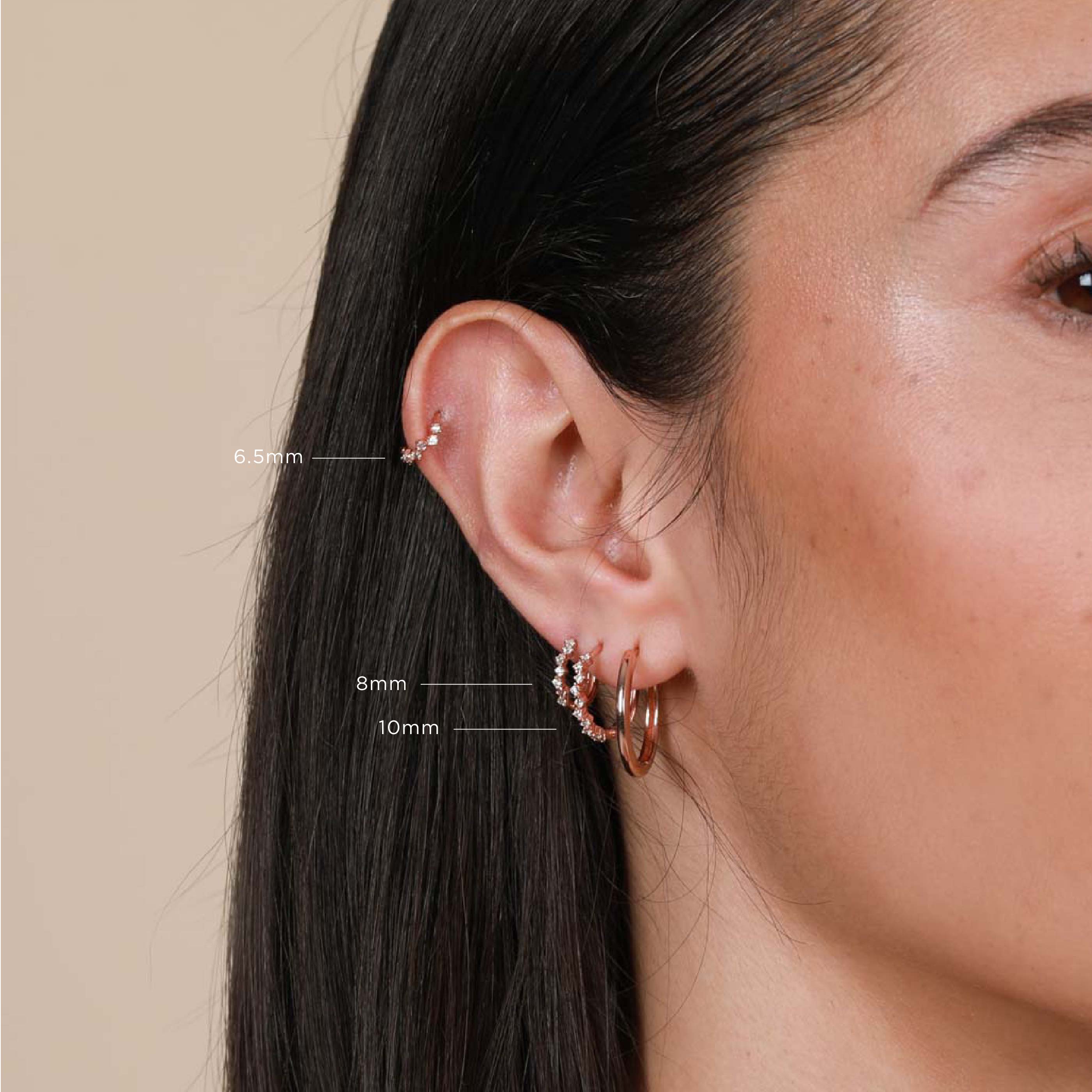 Worn shot of Cluster Hoop 8mm in Rose Gold in upper lobe piercing with other sizes labelled