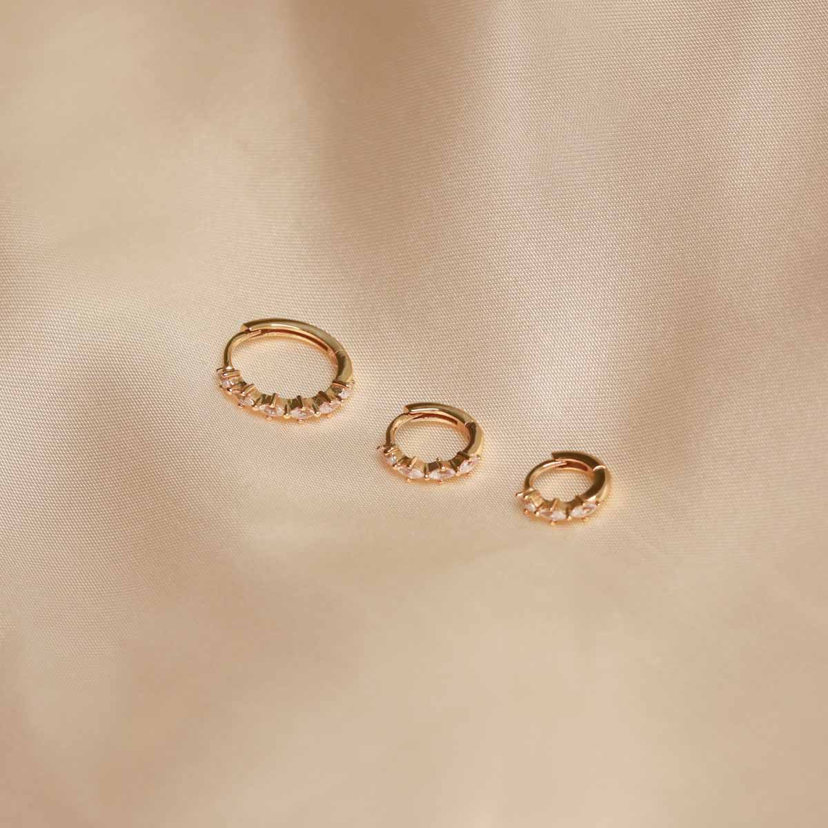 Flat lay shot of all Navette Hoops in Gold sizes