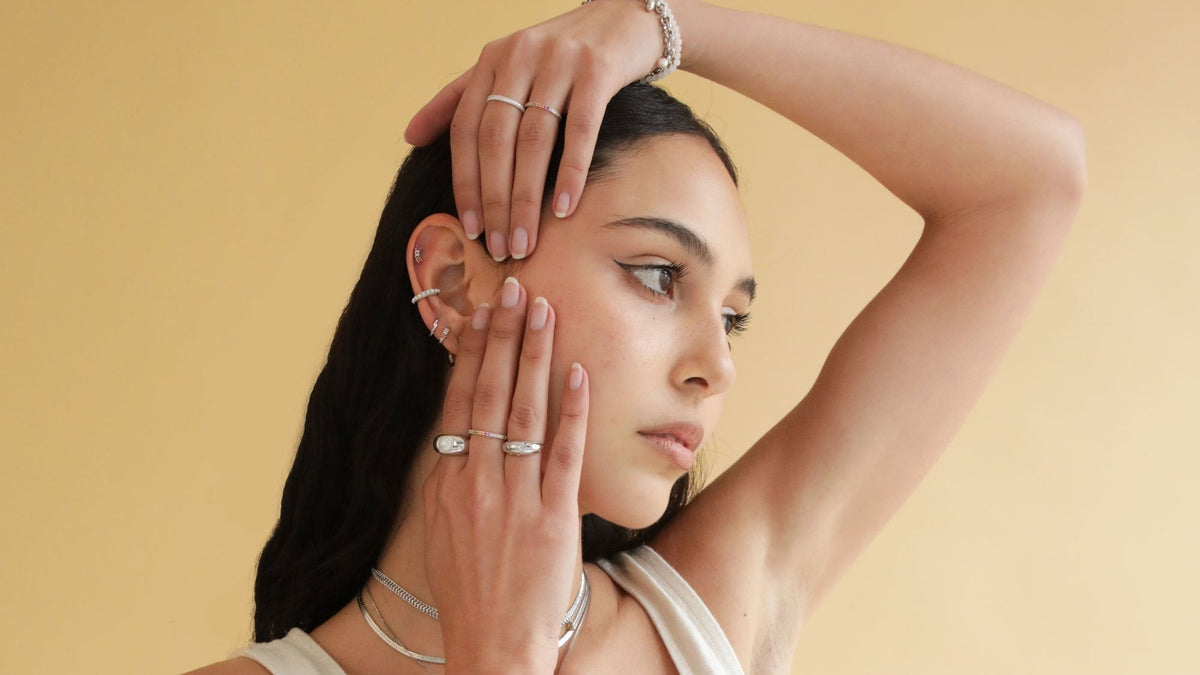 Woman wearing rings and earrings from the Astrid & Miyu Reverie colourful jewellery collection