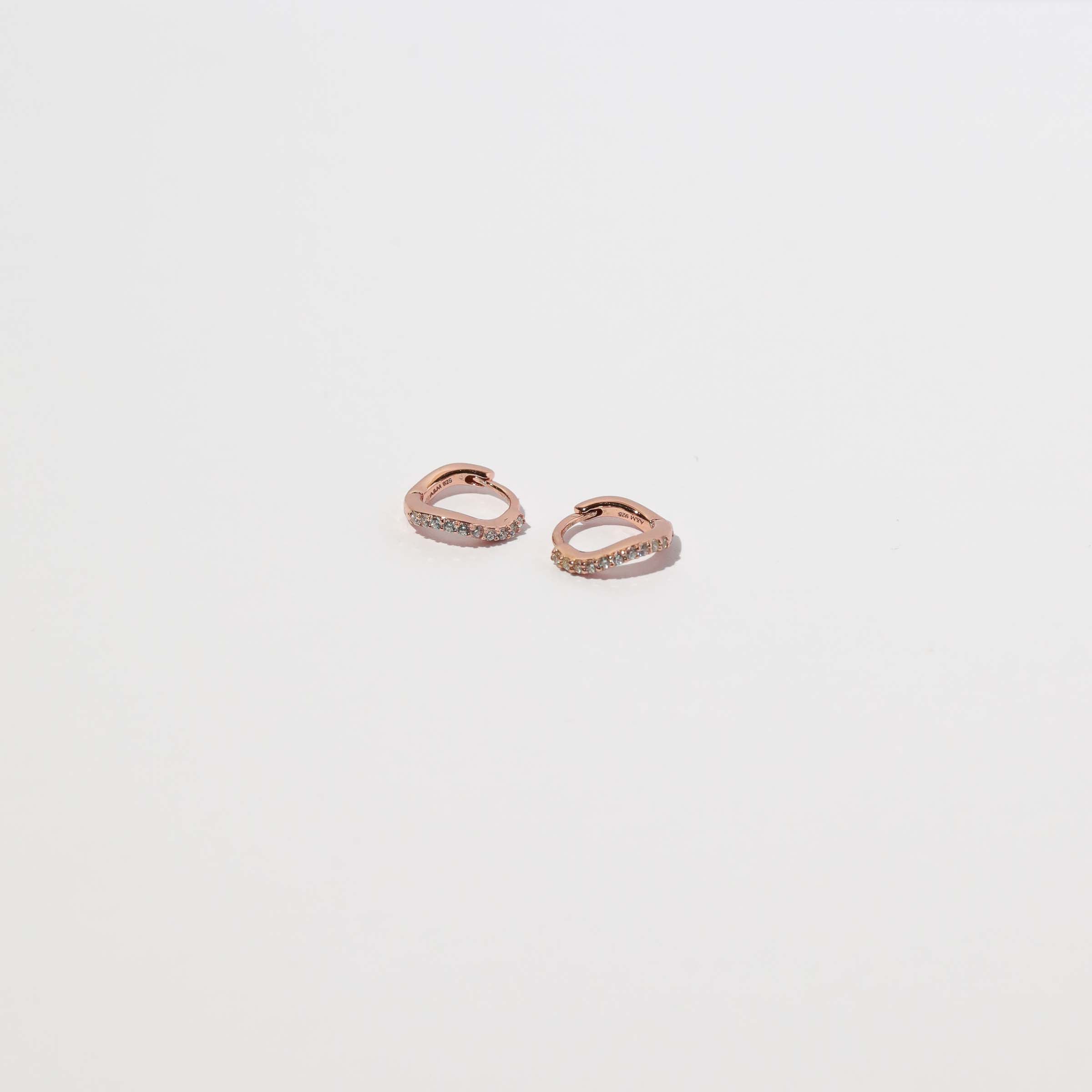 Wave Crystal Huggies in Rose Gold flat lay