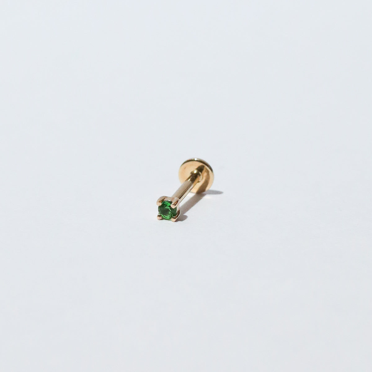 Tsavorite Claw Set Piercing Stud in Solid Gold flat lay