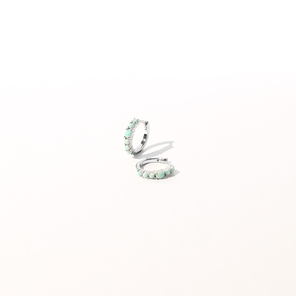 Aura Opal Huggies in Silver flat lay shot