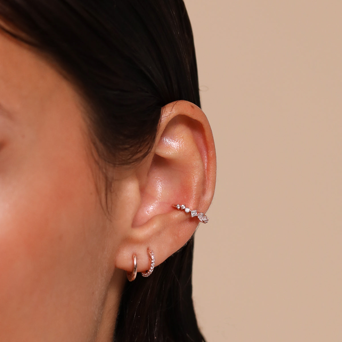 Orbit Crystal Huggies in Rose Gold worn stacked with other earrings