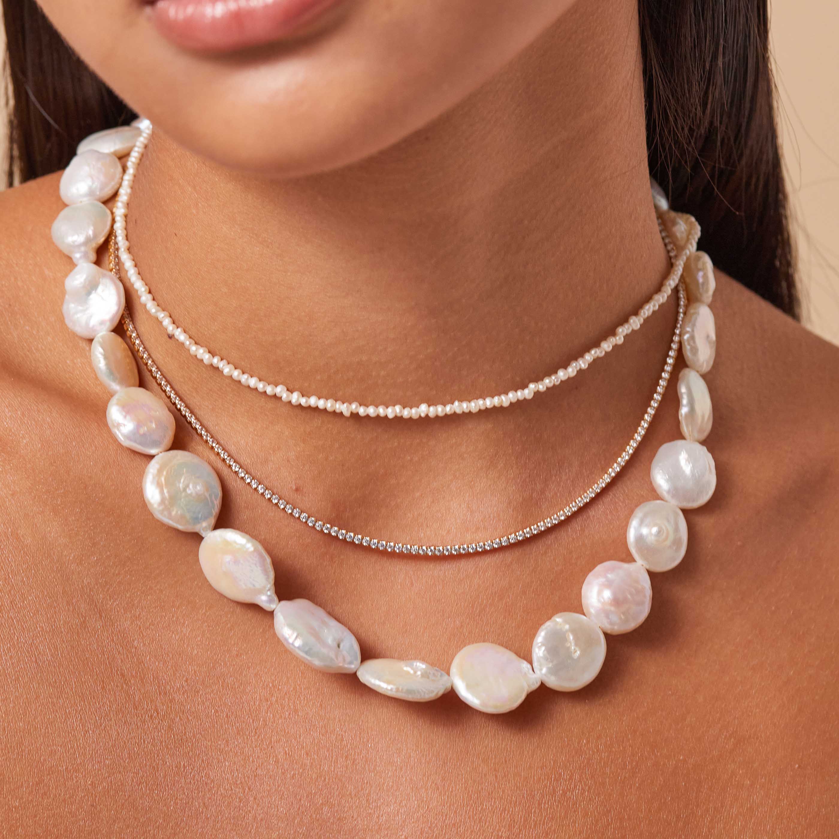 Opulent Pearl Necklace in Gold worn layered with necklaces