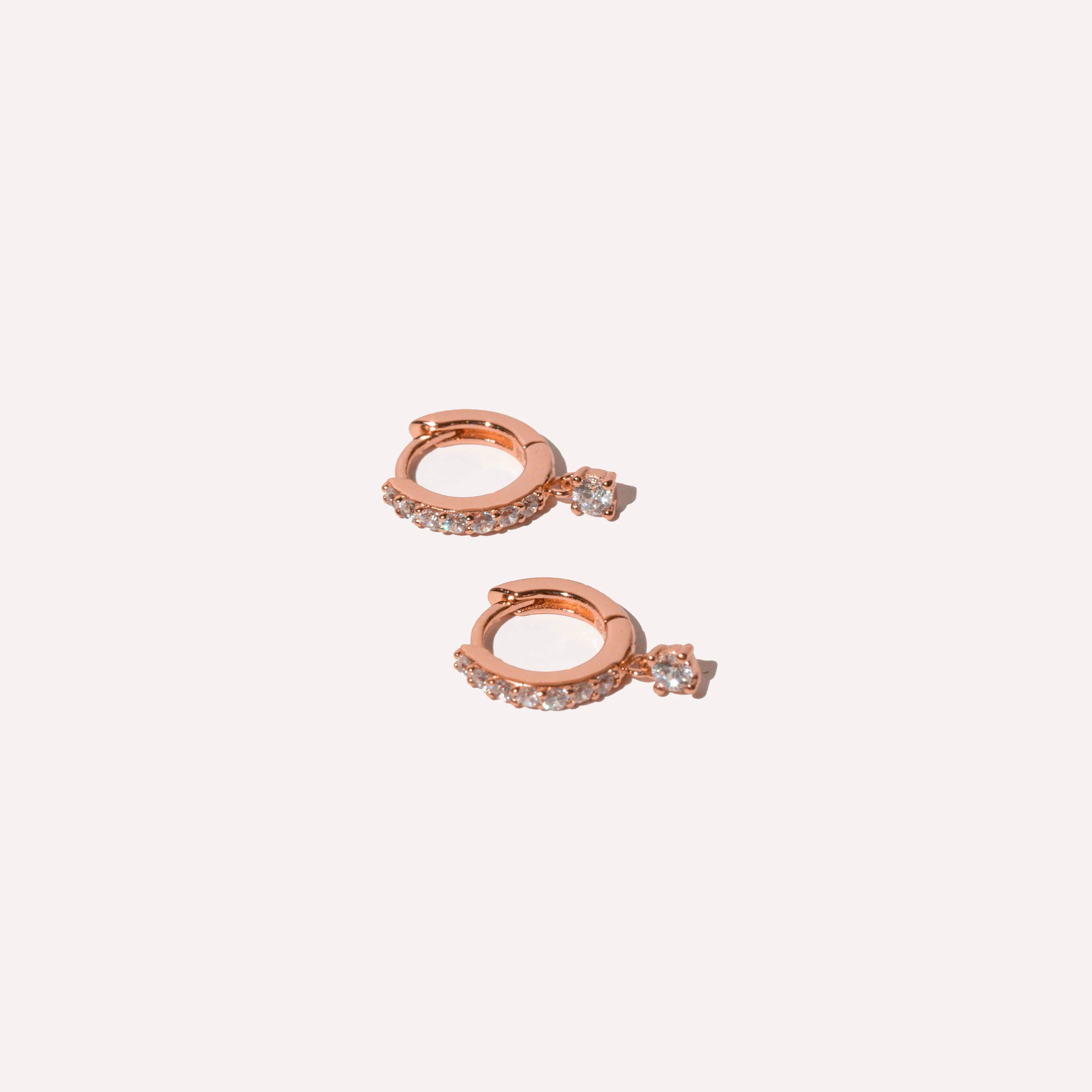 Charm Crystal Huggies in Rose Gold flat lay