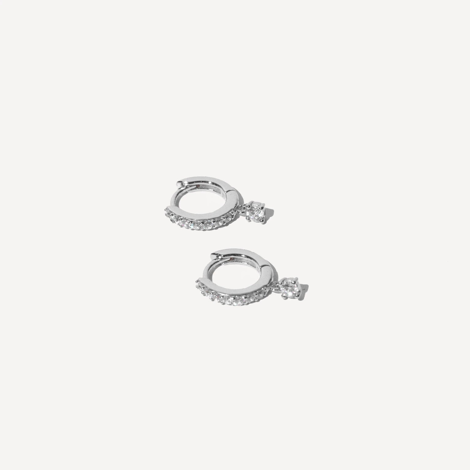 Charm Crystal Huggies in Silver flat lay