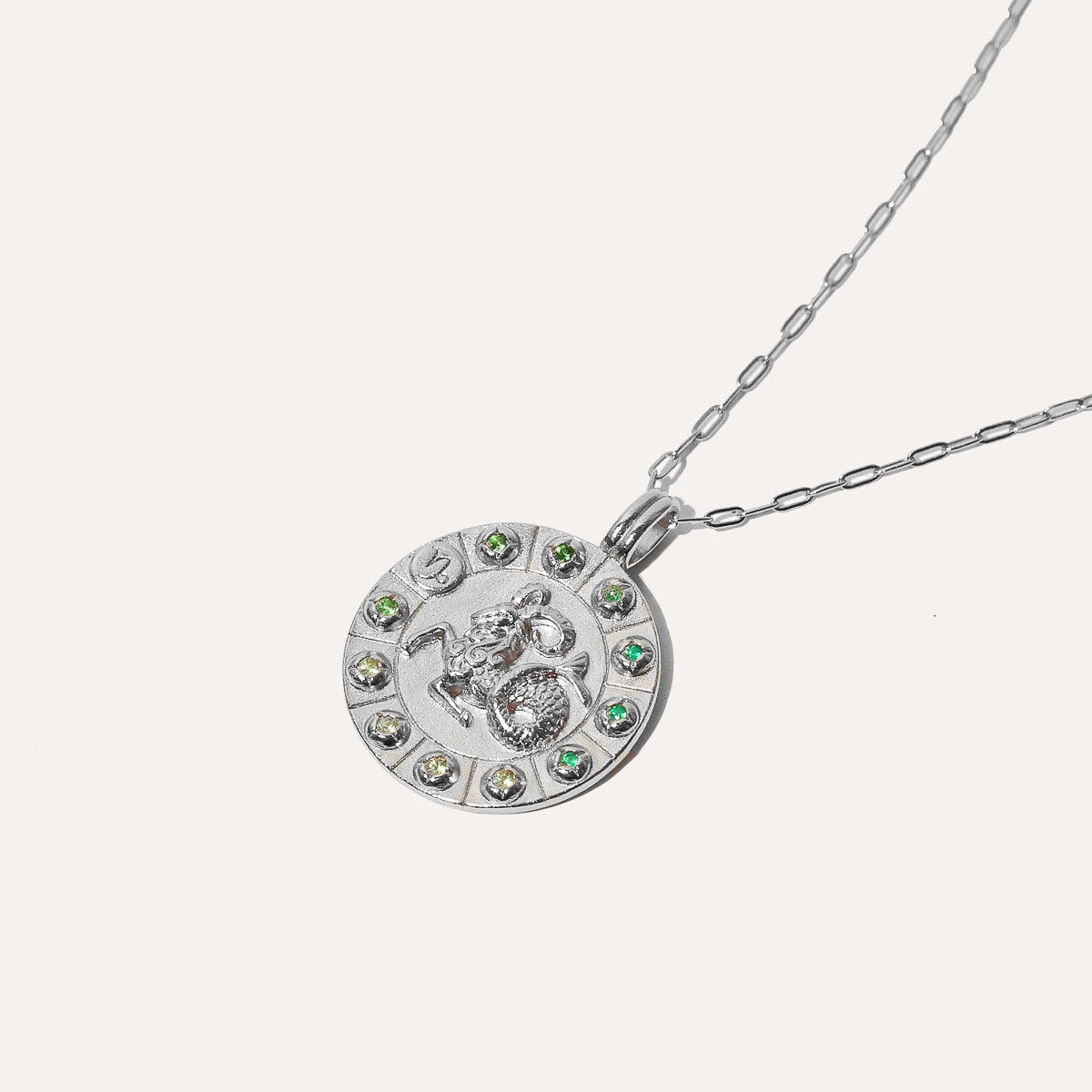 Capricorn Bold Zodiac Pendant Necklace in silver flat lay