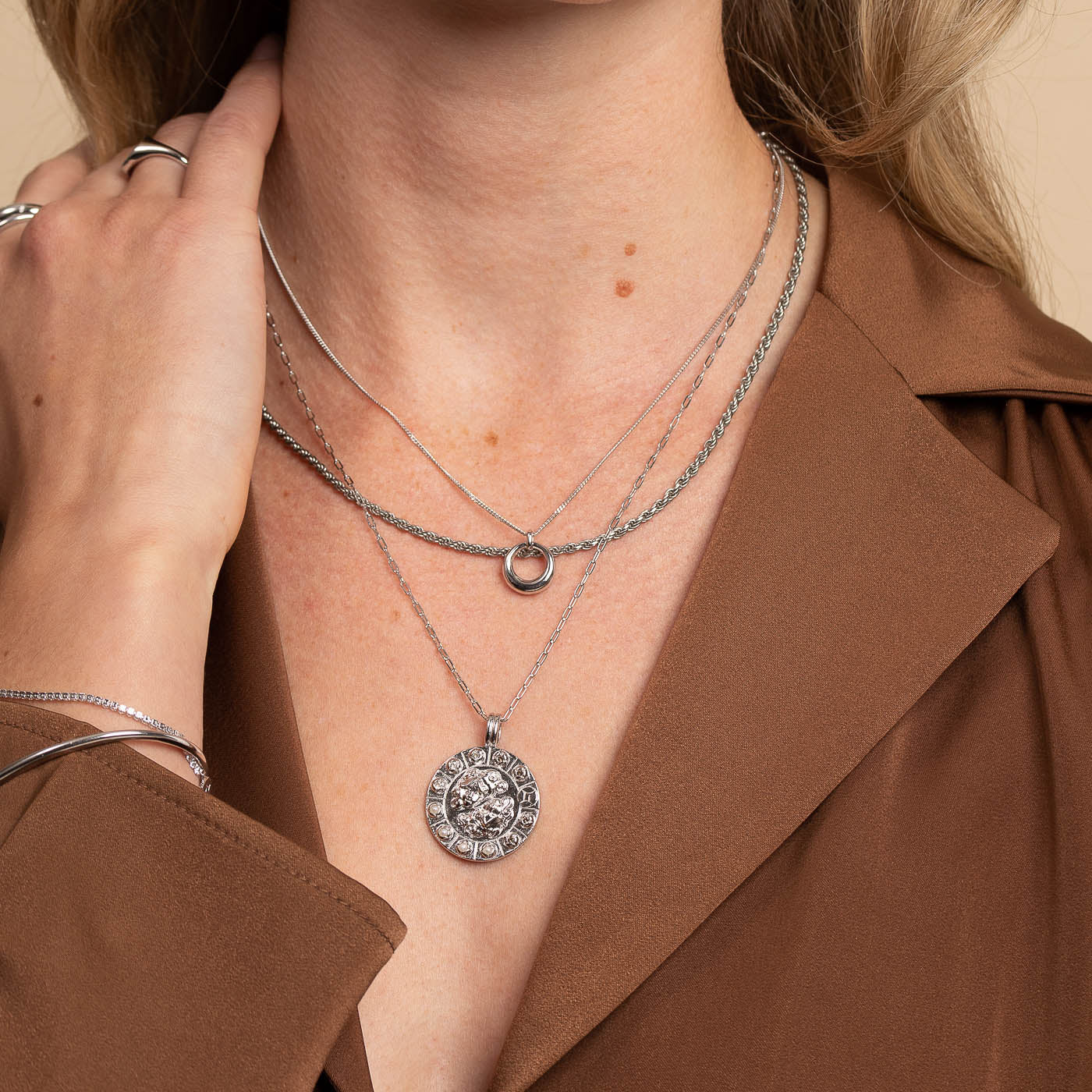 Gemini Bold Zodiac Pendant Necklace in Silver worn layered with halo pendant necklace and rope chain necklace
