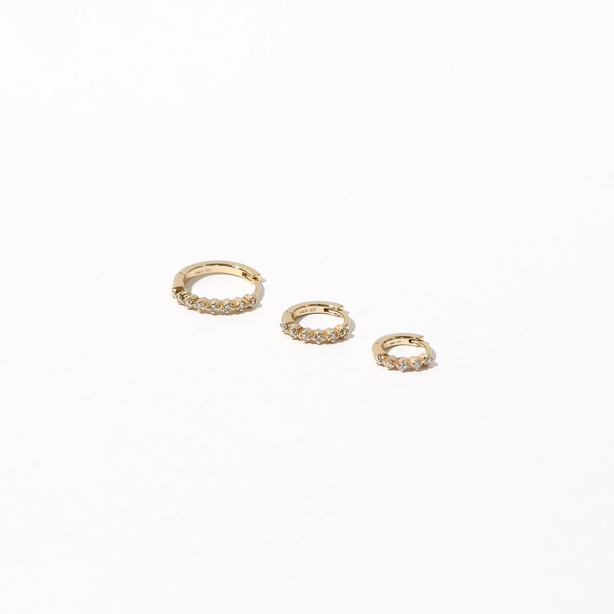 Illume Crystal 6.5mm, 8mm, 11.5mm Hoops in Gold flat lay shot