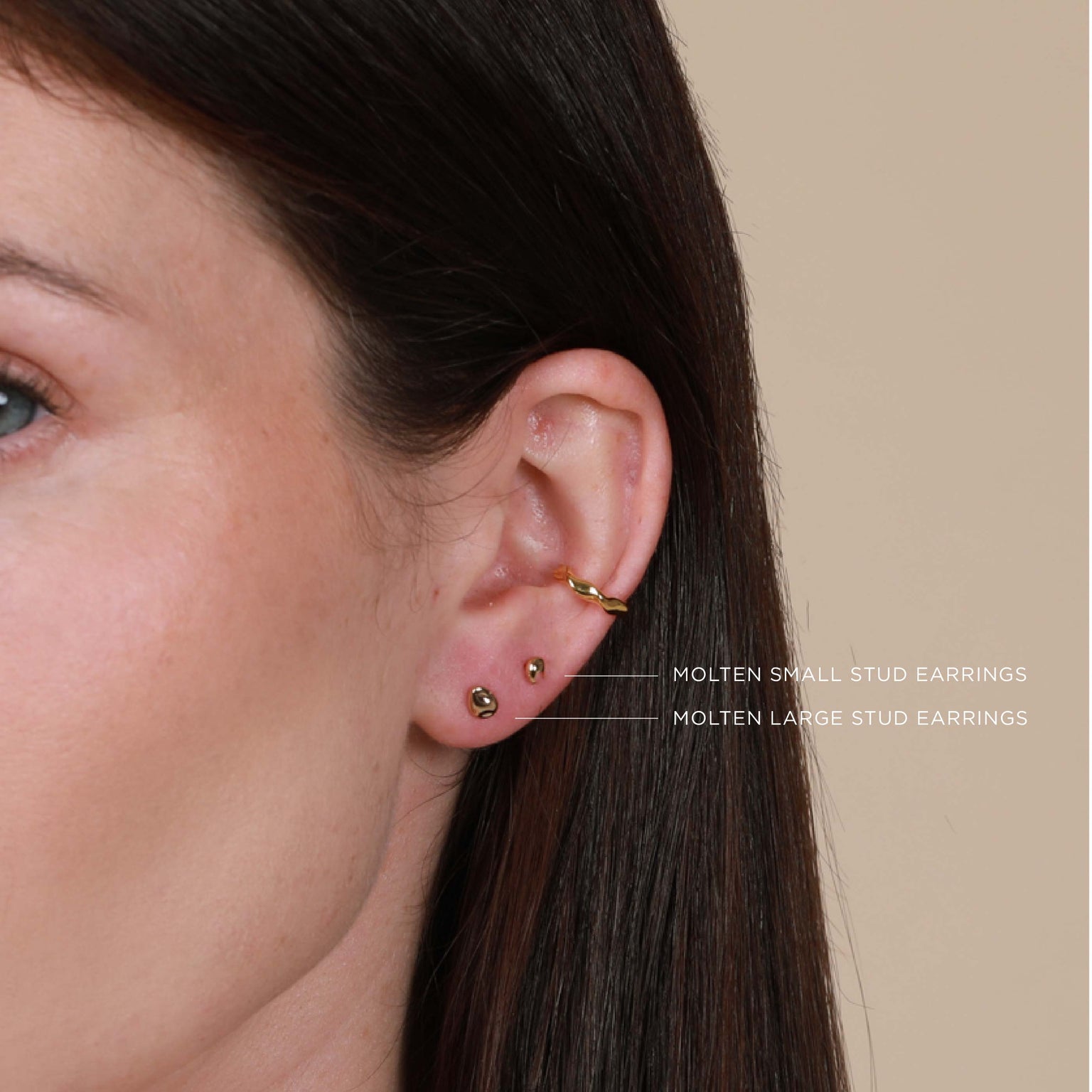 Worn shot of Molten Small Stud Earrings in Gold in upper lobe piercing