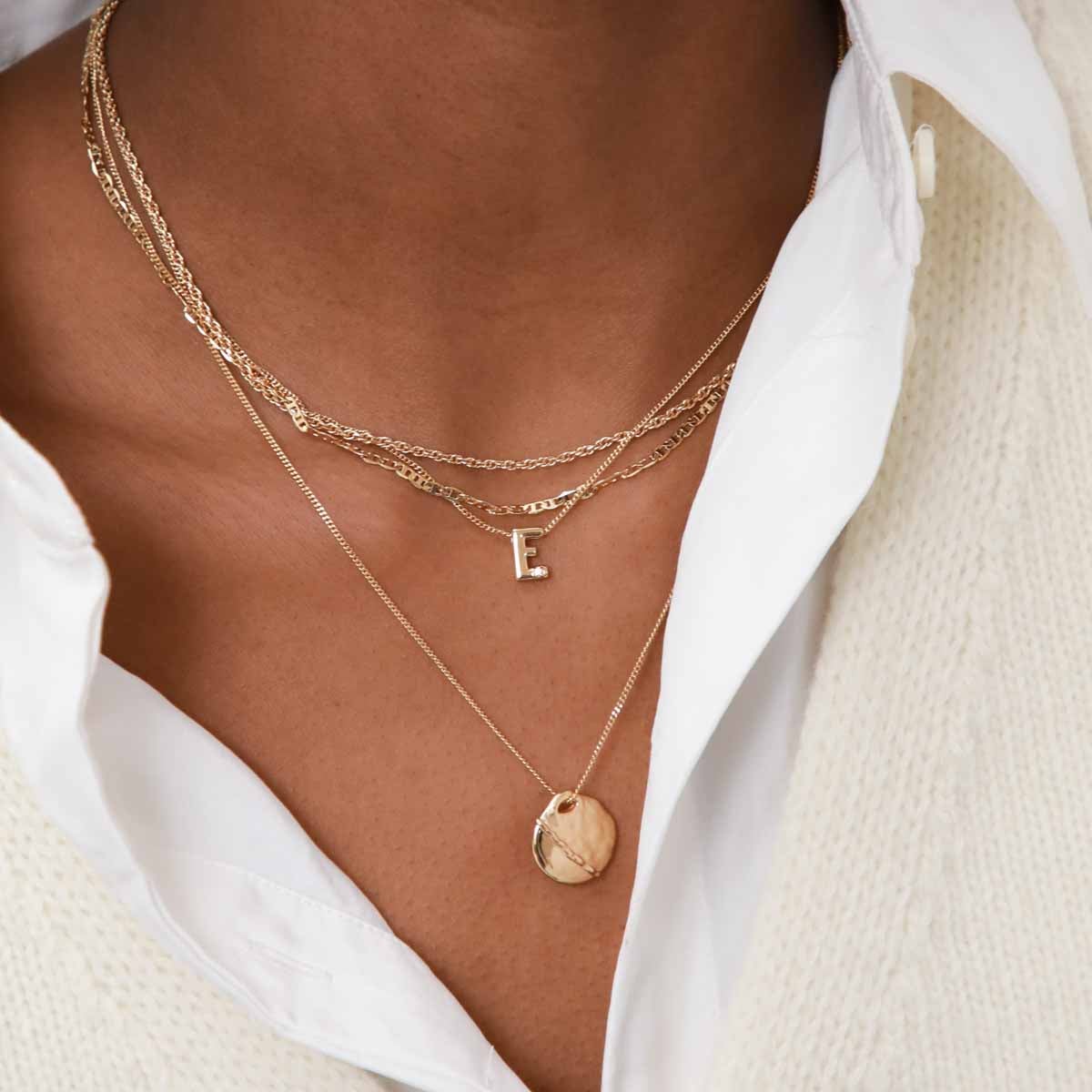 E Initial Pendant Necklace in Gold worn layered with duo chain necklace and molten coin pendant necklace