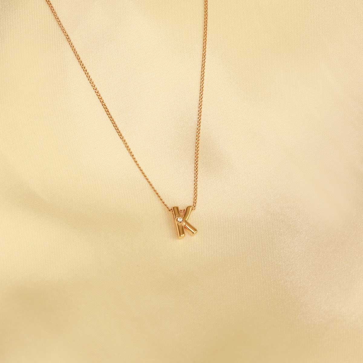 Flat lay shot of K Initial Pendant Necklace in Gold