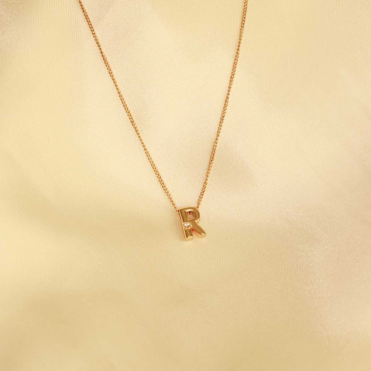 Flat lay shot of R Initial Pendant Necklace in Gold