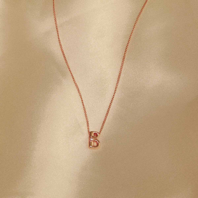 Flat lay shot of B Initial Pendant Necklace in Rose Gold