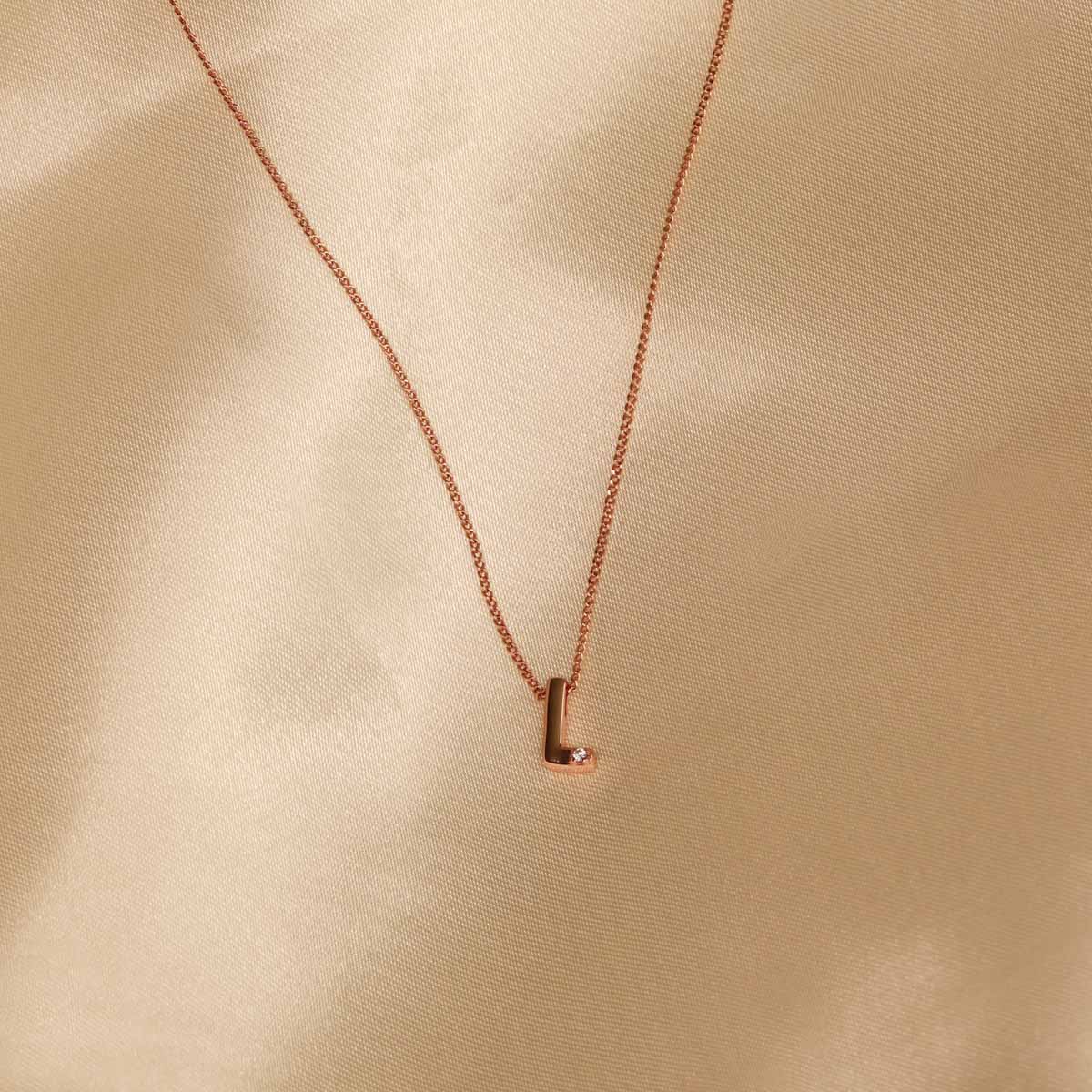 Flat lay shot of L Initial Pendant Necklace in Rose Gold