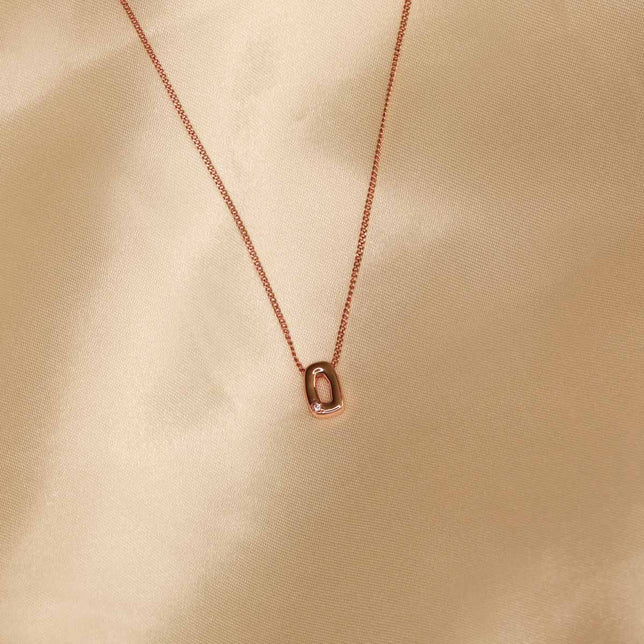 Flat lay shot of O Initial Pendant Necklace in Rose Gold