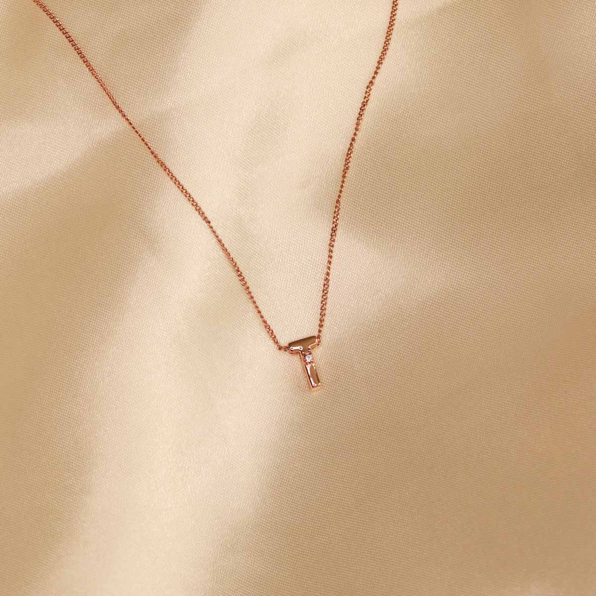 Flat lay shot of T Initial Pendant Necklace in Rose Gold
