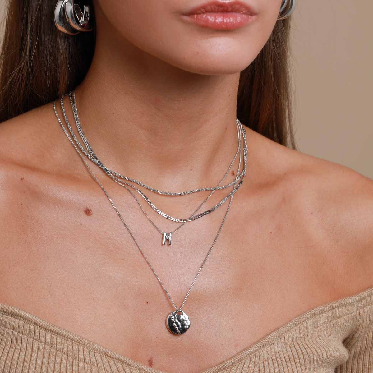M Initial Pendant Necklace in Silver worn layered with duo chain necklace and molten coin pendant necklace