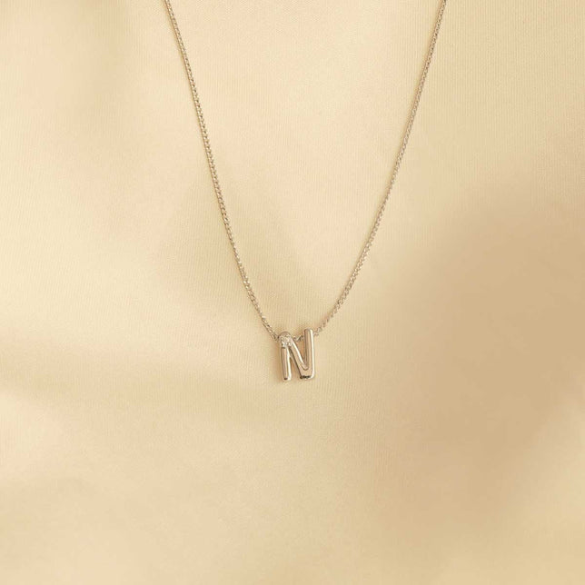 Flat lay shot of N Initial Pendant Necklace in Silver