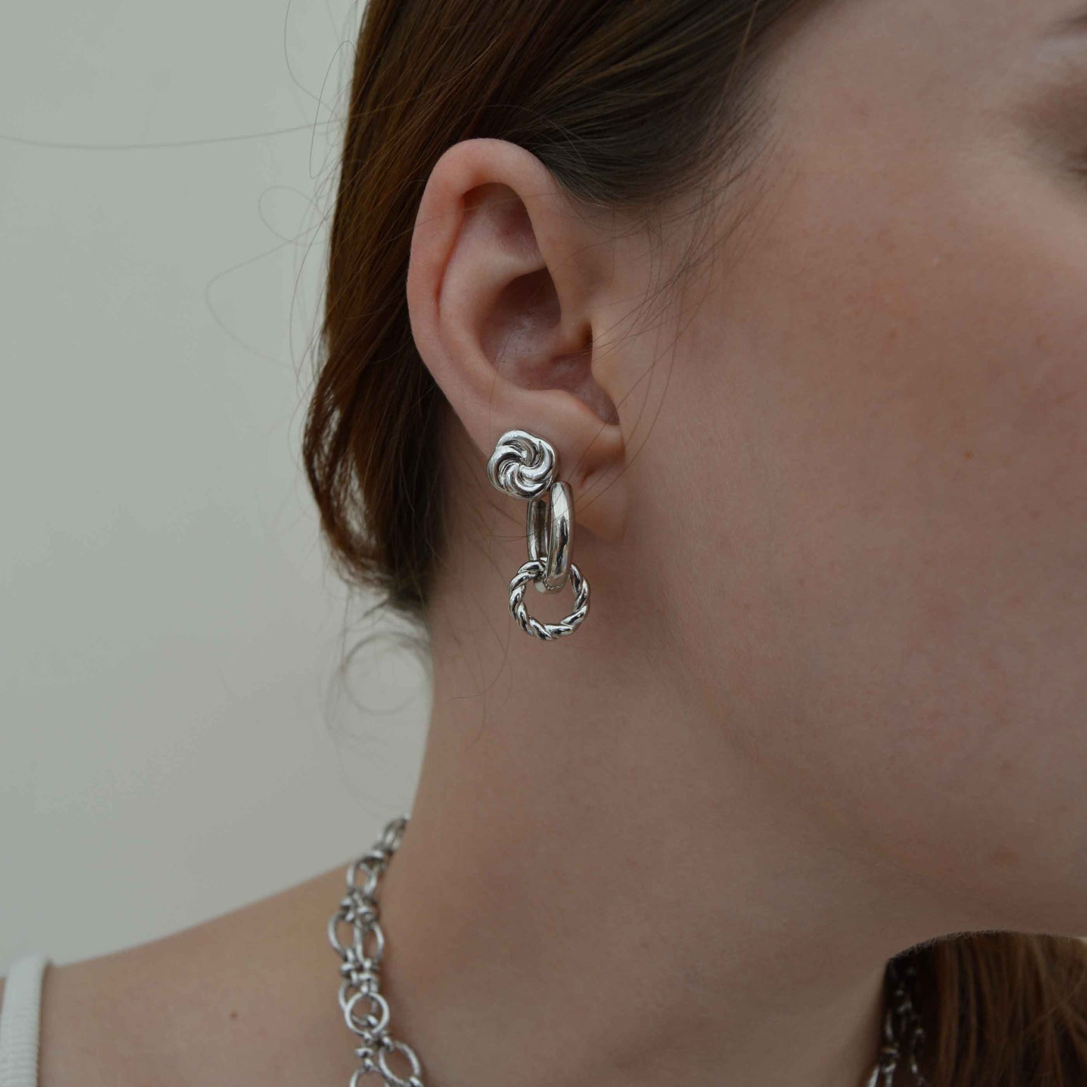 Knot Stud Earrings in Silver worn with silver hoops