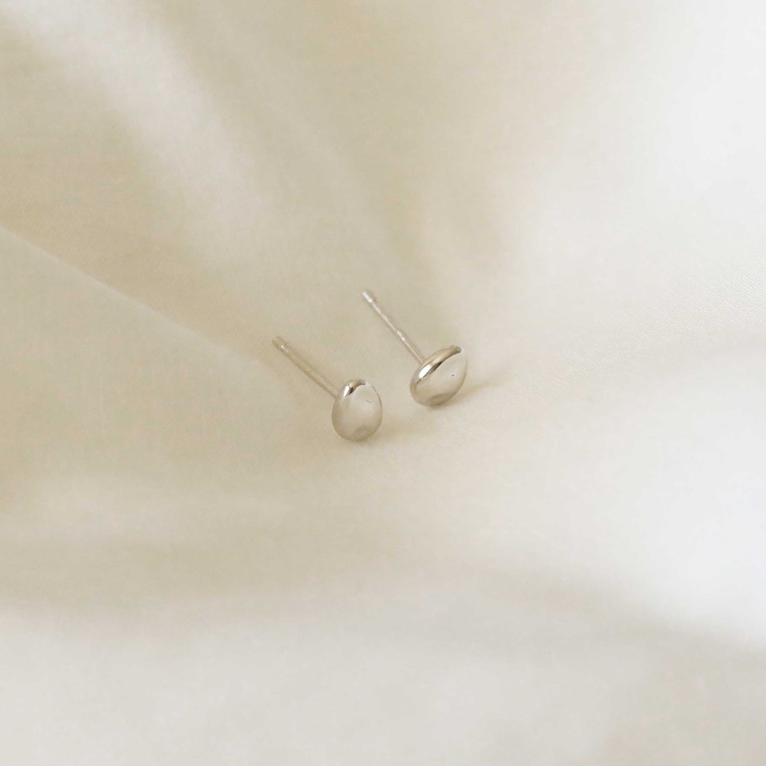 Flat lay shot of Molten Large Stud Earrings in Silver