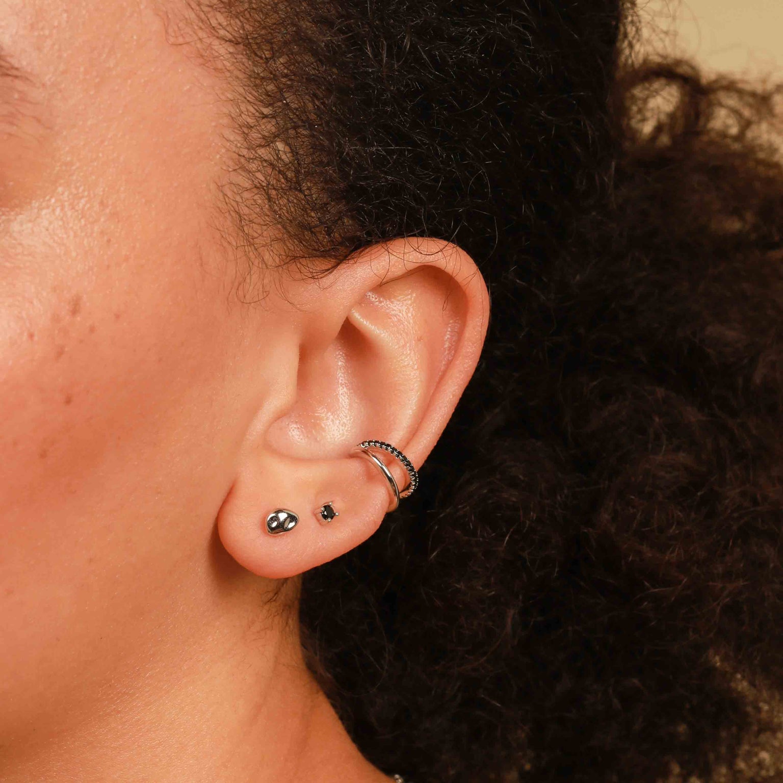 Worn shot of Molten Large Stud Earrings in Silver in front lobe