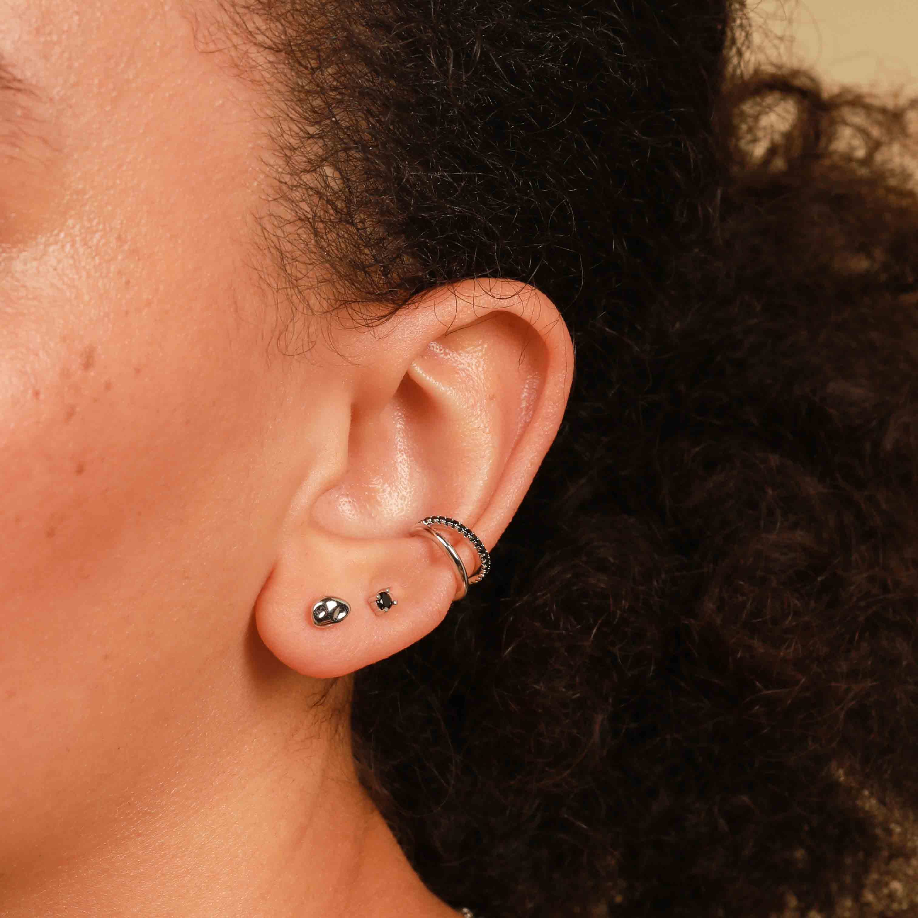 Worn shot of Molten Large Stud Earrings in Silver in front lobe