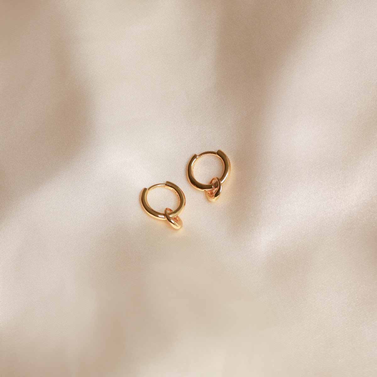 Flat lay shot of Molten Charm Hoops in Gold