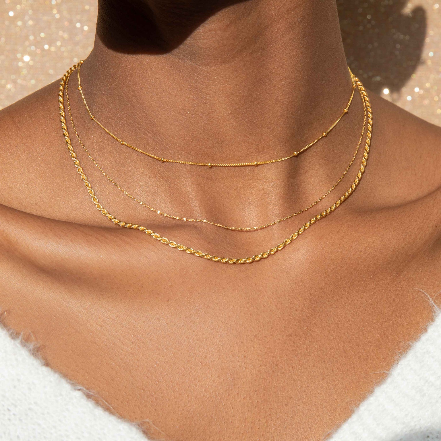 rope chain necklace in gold worn with dainty gold chains