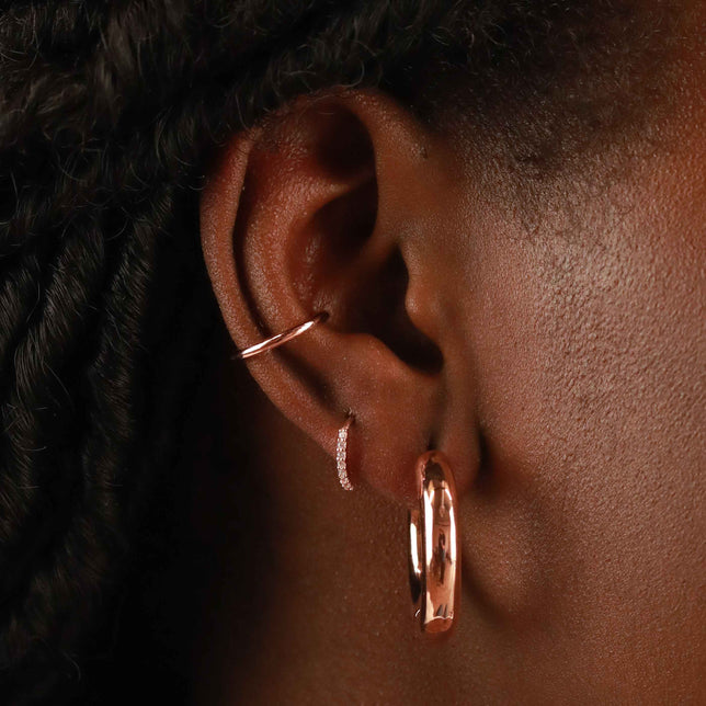 Worn shot of Crystal Jewelled Huggies in Rose Gold in upper lobe piercing location