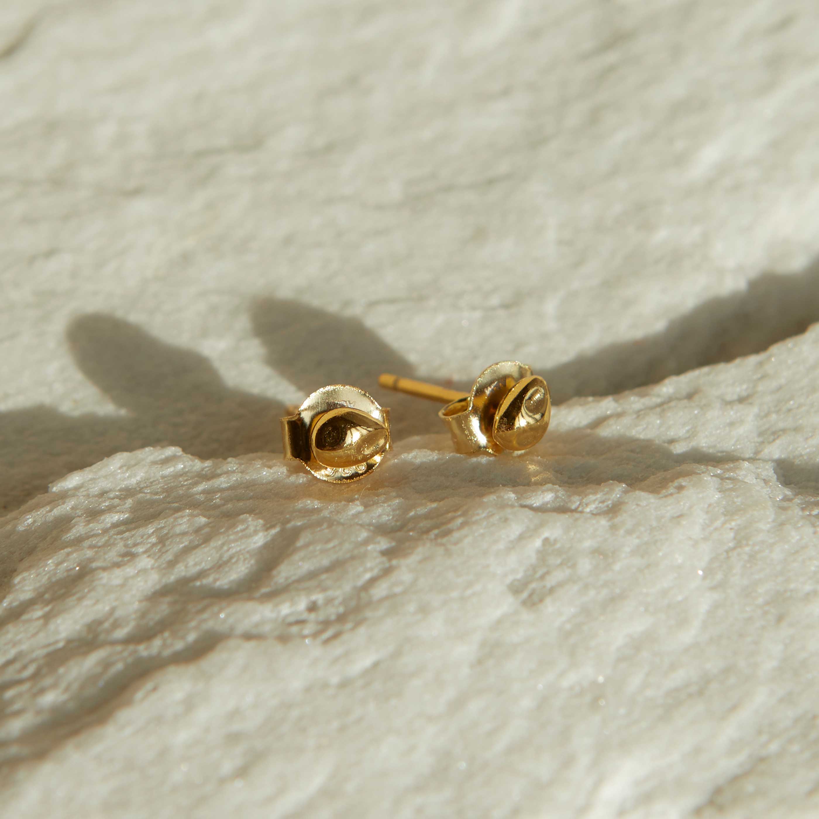 Flat lay shot of Molten Stud Earrings in Gold