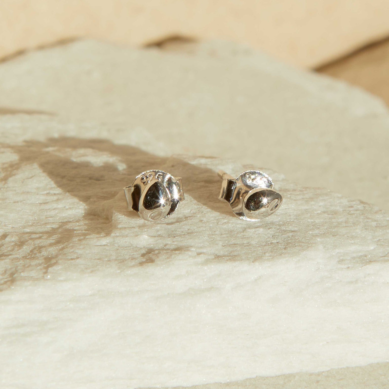 Flat lay shot of Molten Stud Earrings in Silver